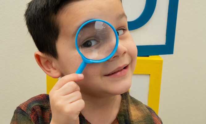 Kid holding magnifying glass