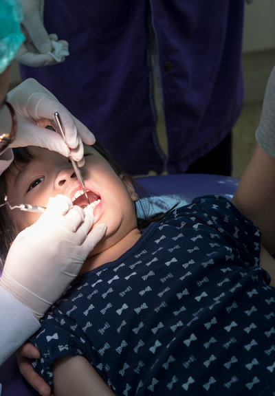 Asian girl met the dentist for routine dental checkup and fluoride treatment. Closed up cleaning process.